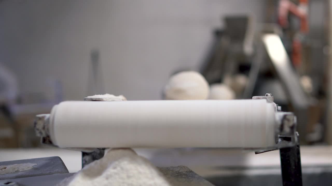 面包制造厂传送带上的面团成型机。视频素材