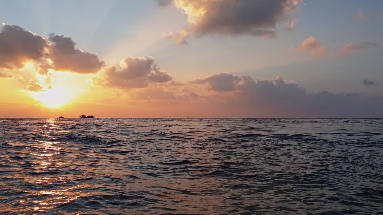 马尔代夫海上令人惊叹的黄金时刻日落。慢动作低角度平移视频素材
