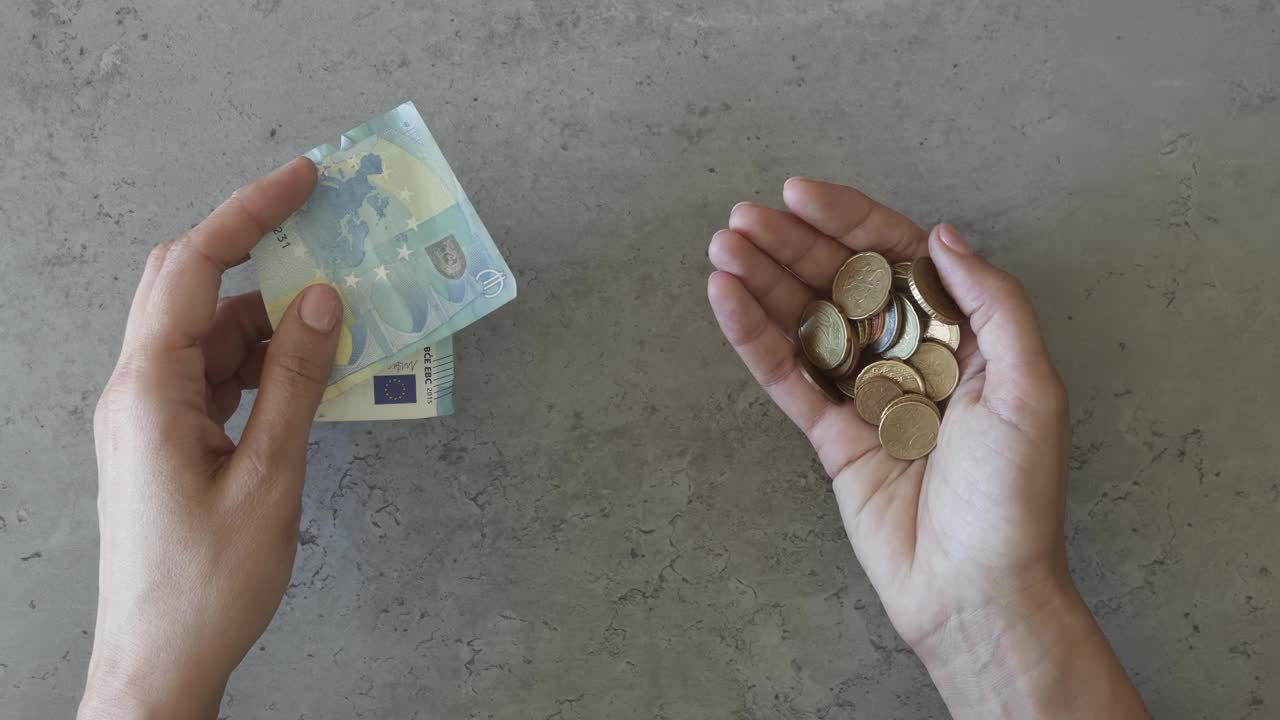 女性的手在数钱。女士在餐桌上放了20欧元。她拿着一把硬币，挑出几欧元放在桌子上。购买商品或服务，危机，纳税，最后的钱视频下载