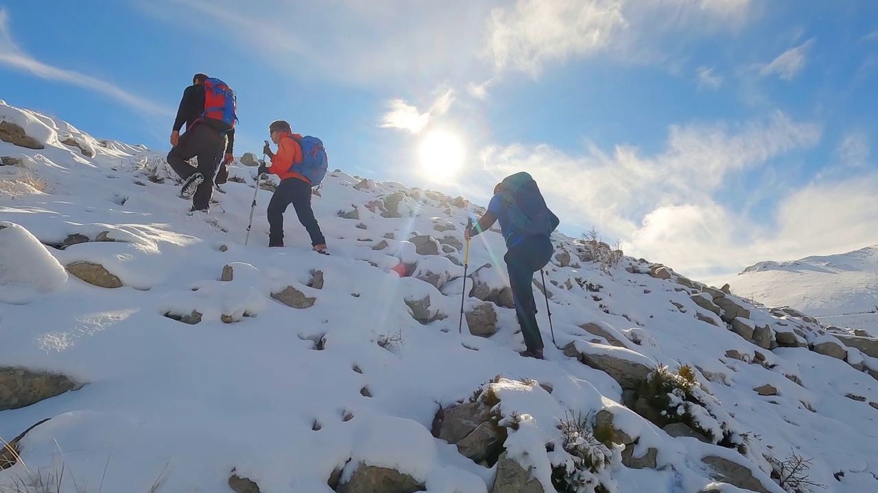 成功的登山队正在冬天的雪山山顶的山脊上排成一行视频素材