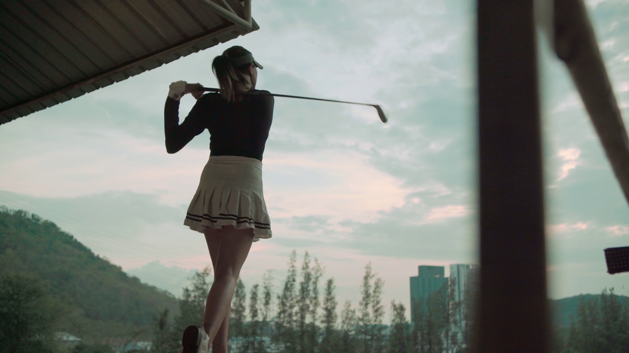 女子高尔夫球手与高尔夫挥杆对抗视频素材