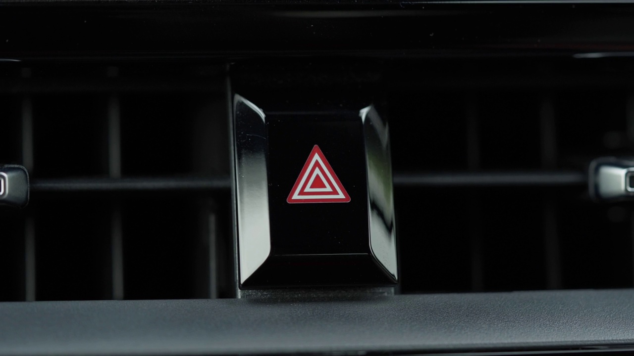 食指按在汽车仪表板上的乘用车危险灯按钮的特写。事故紧急标志和情况视频素材