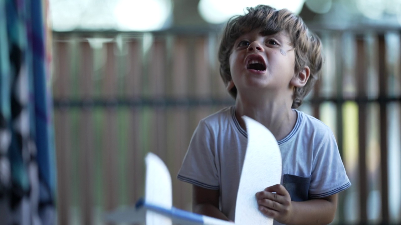 一个愤怒的小男孩一边拿着飞机玩具一边发脾气。烦恼不安的孩子视频素材