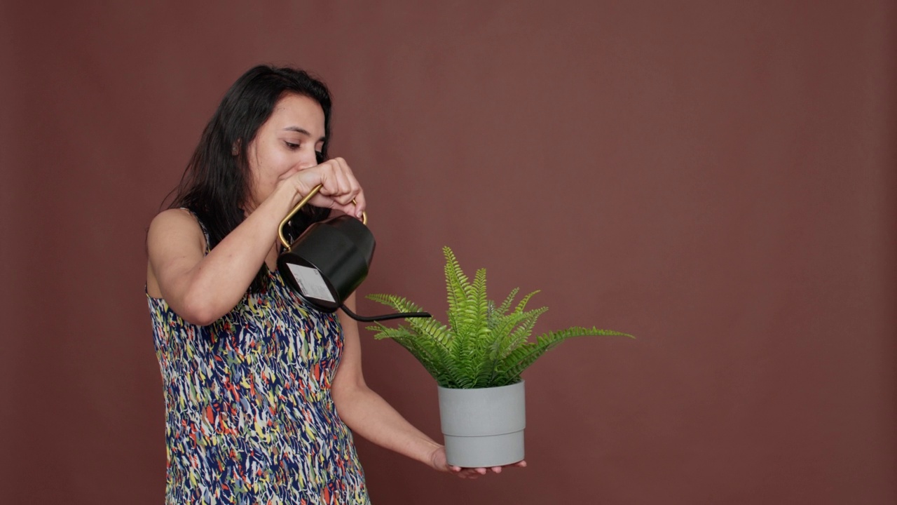 快乐的模特捧着花盆，浇着绿色的植物视频素材