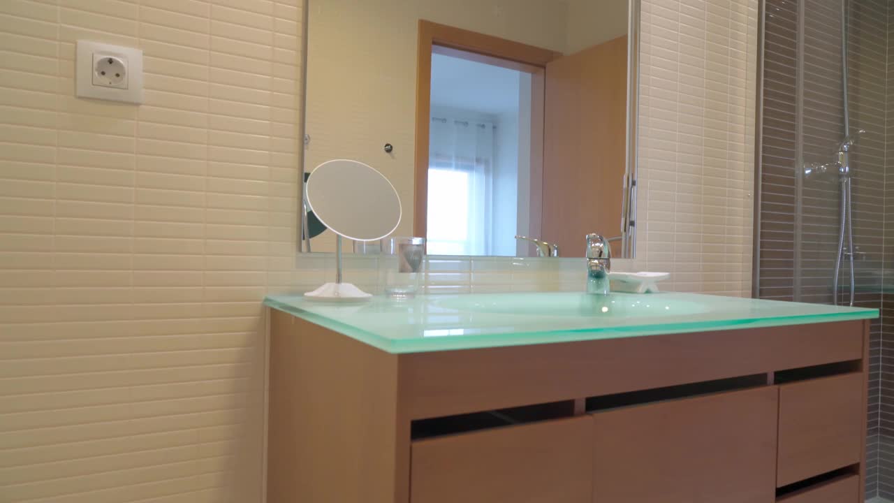 带淋浴的现代化浴室，在一家旅游酒店。房间里卧室的倒影视频素材