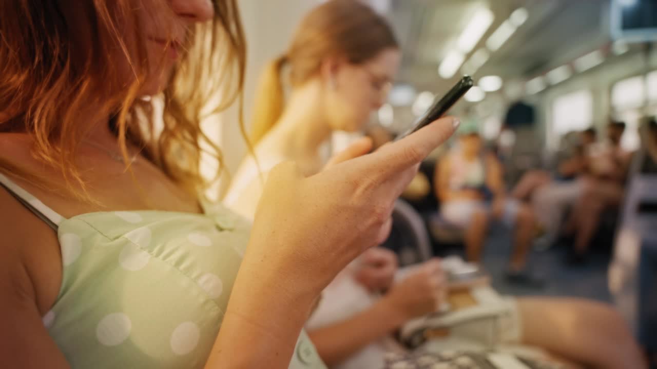 一个女孩在坐火车旅行时浏览她的手机视频素材