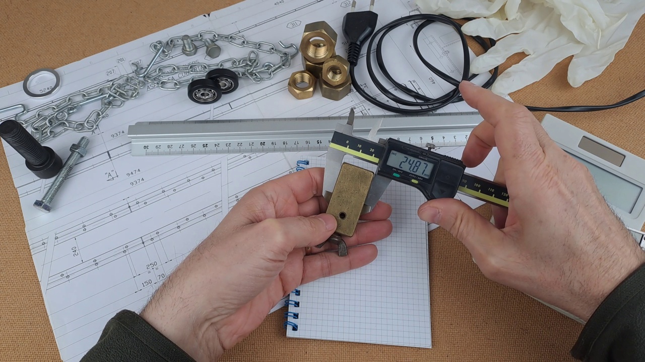 测量设备用卡尺测量钻过的黄铜块视频下载