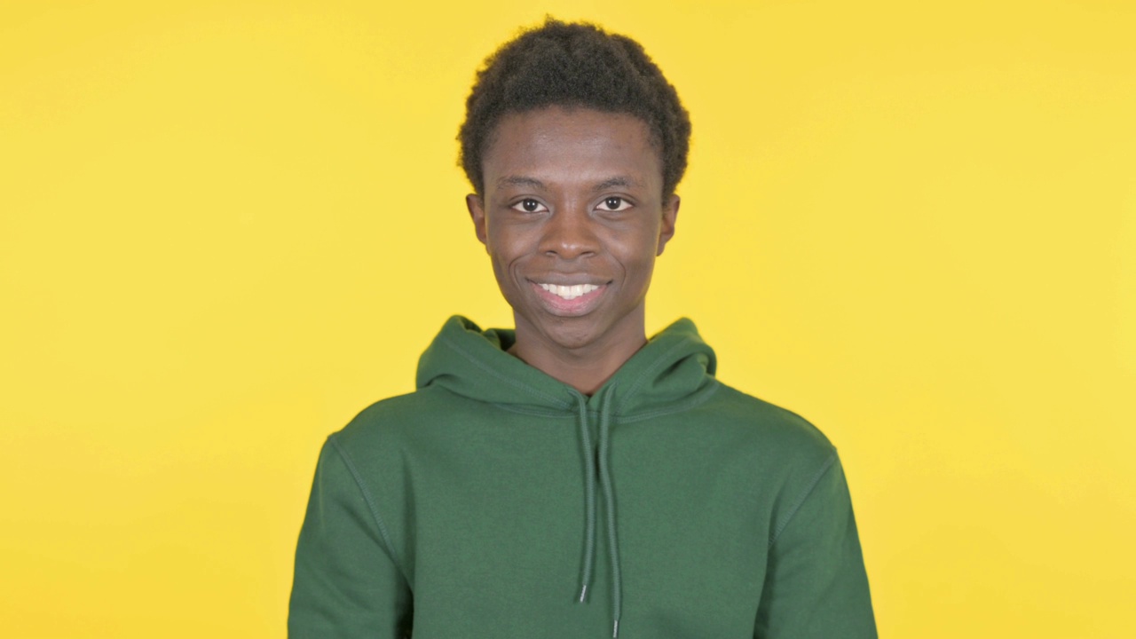 微笑的年轻非洲人在黄色背景视频下载