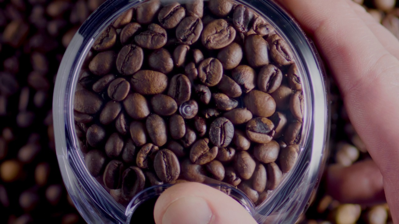 近距离的咖啡种子研磨在电动研磨机的顶部视图。手持罩视频下载