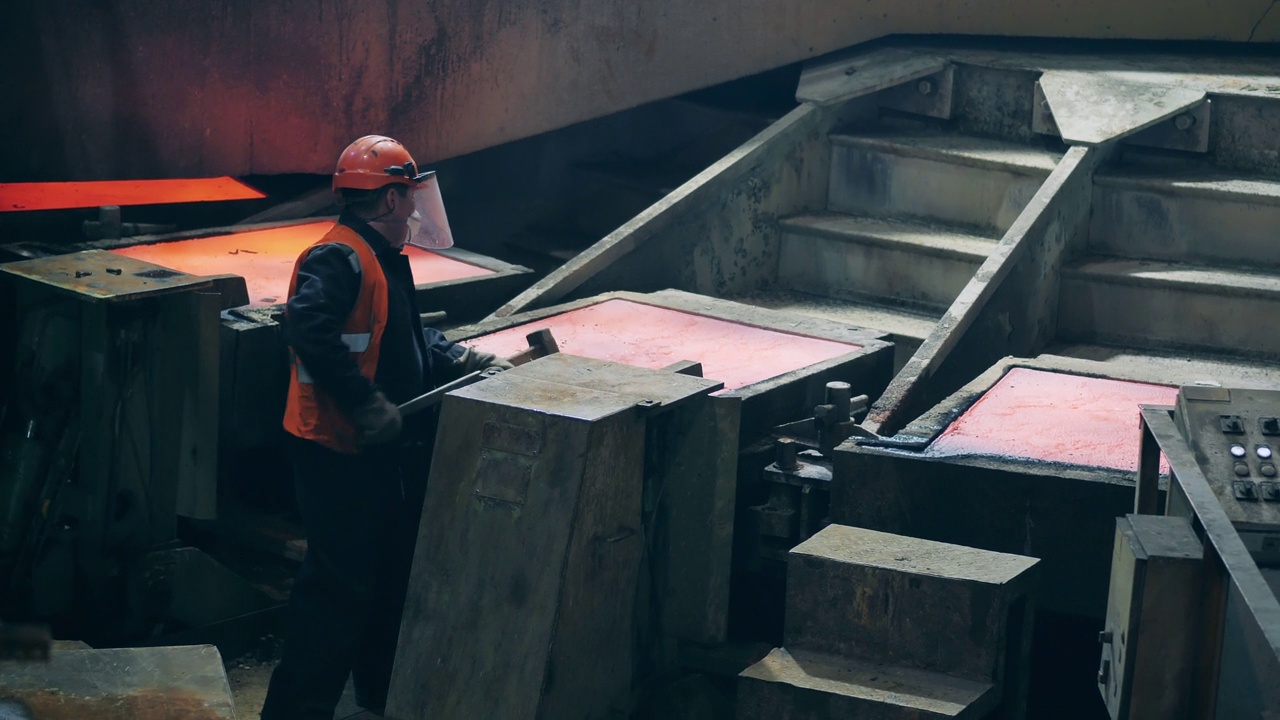 工厂工人正在模具中敲击凝固铜视频素材