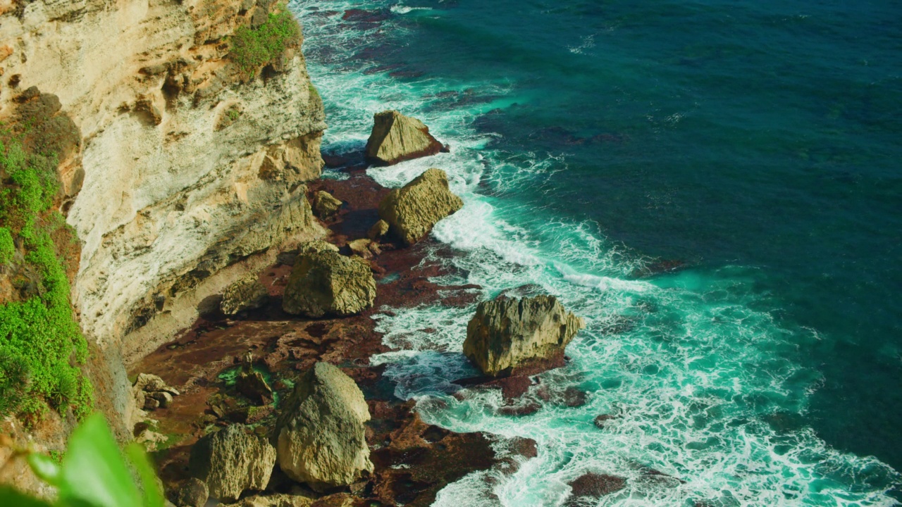 石崖绿松石深海岩石海滩浪花泡沫。热带景观。静态自顶向下视图。印度尼西亚巴厘岛乌鲁瓦图的自然风光。视频下载