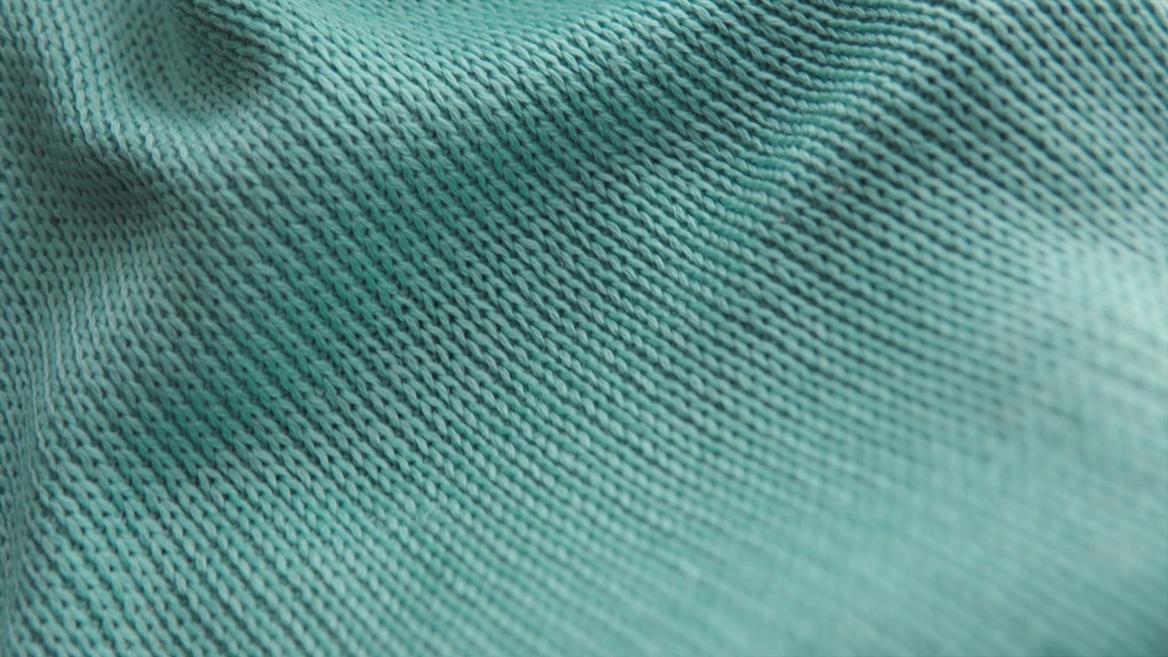 一件柔软舒适的绿色丙烯酸针织毛衣的特写镜头。视频下载
