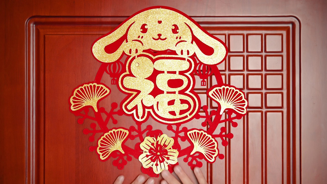 一名男子把中国兔年的装饰贴在一扇门上，在水平构图翻译的中文单词是幸运没有标志没有商标视频下载