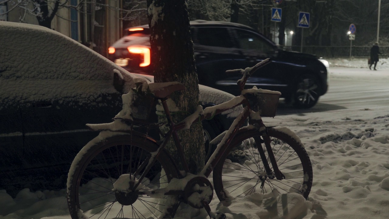 一辆自行车在雪中树下不是季节，汽车都从旁边经过视频素材