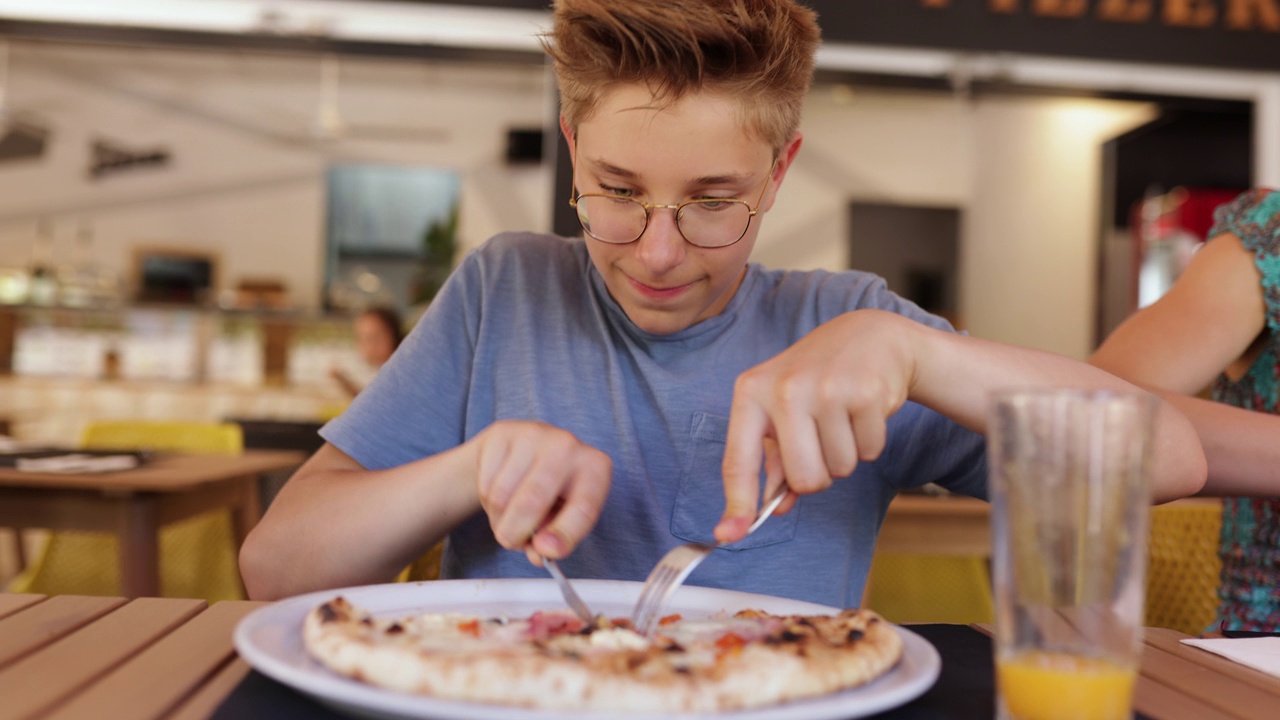 青少年在餐厅吃披萨午餐视频素材