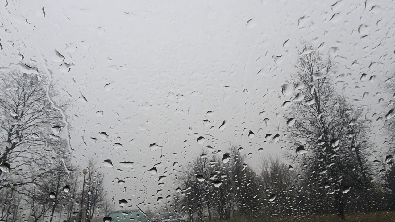 时间通过汽车的挡风玻璃流逝。下雨了视频素材