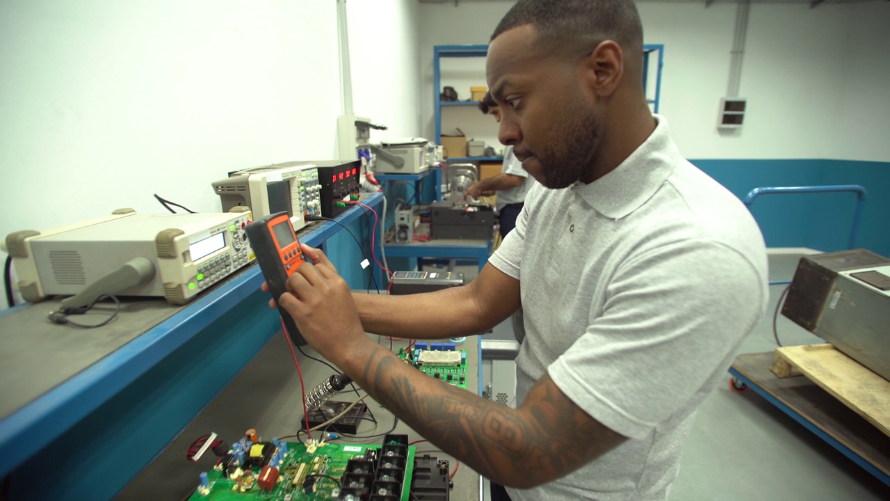 黑人学生在技术学校实习期间使用带电路的低压测试仪视频下载