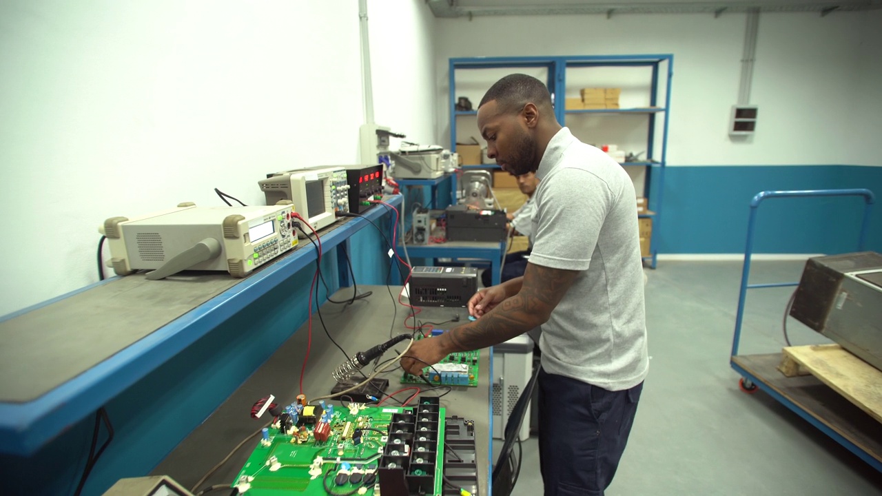 黑人学生在技术学校实习期间使用带电路的低压测试仪视频下载