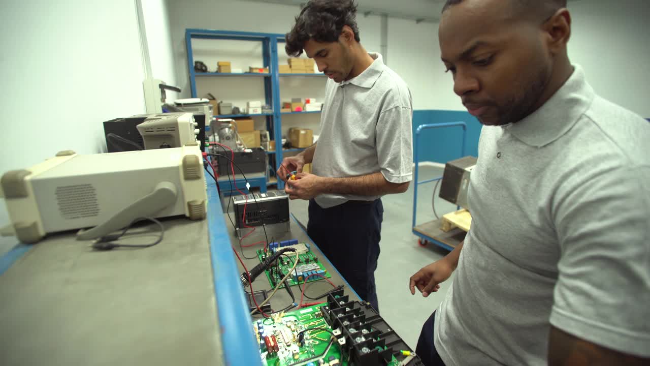两名男学生在技术学校实习期间测试和组装电子电路视频下载