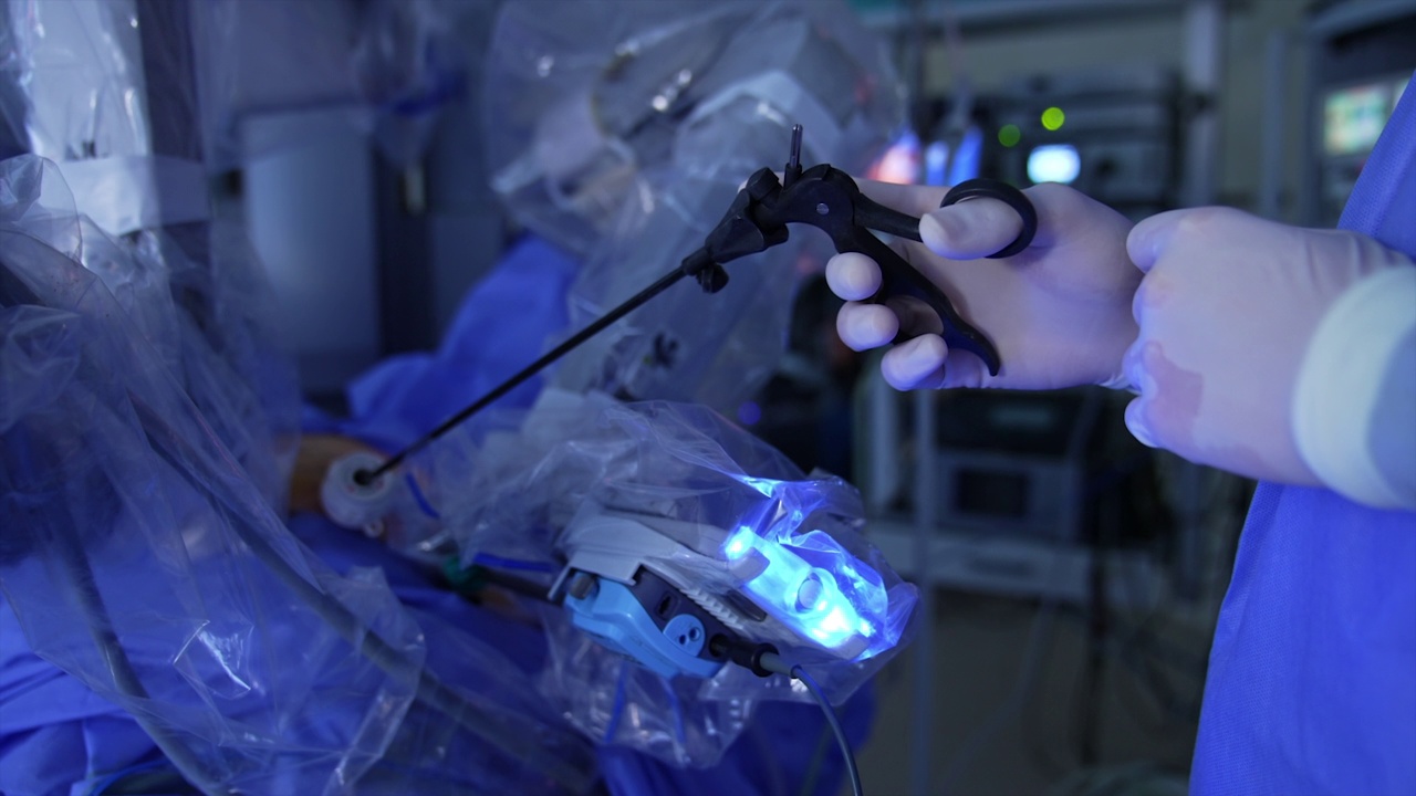 创新的机器人外科医生在现代诊所为病人手术。医生的手握着病人体内长长的黑色仪器。关闭了。视频下载