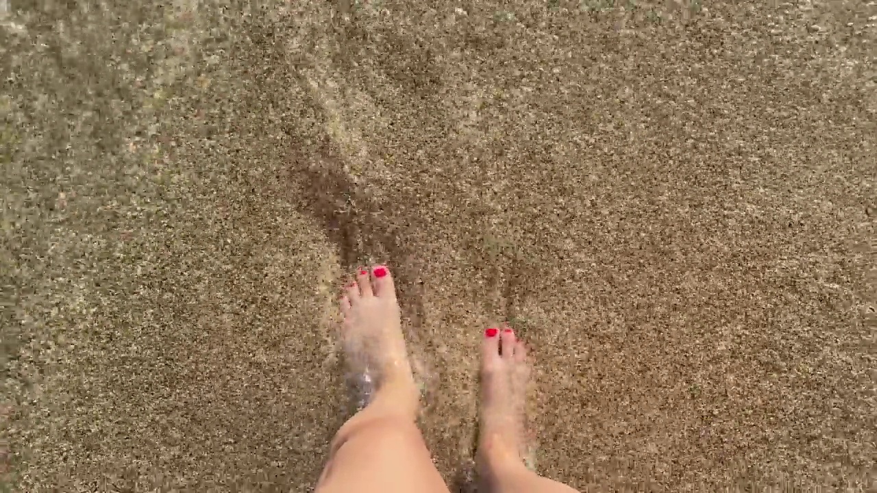 女性的腿脚和海浪咸咸的海水在沙滩上与黄沙在海上飞溅在一个热带天堂度假在东部温暖的国家视频素材