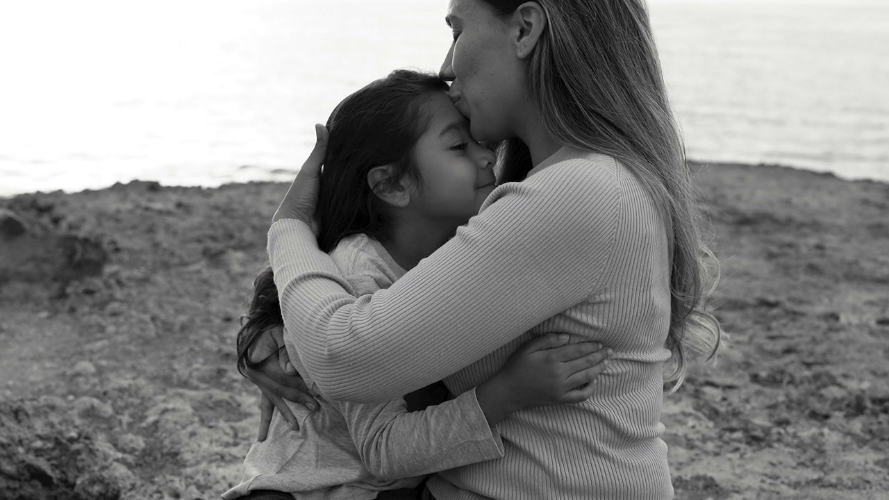 快乐的拉丁母亲与小女儿在海滩上共度温情时刻视频下载