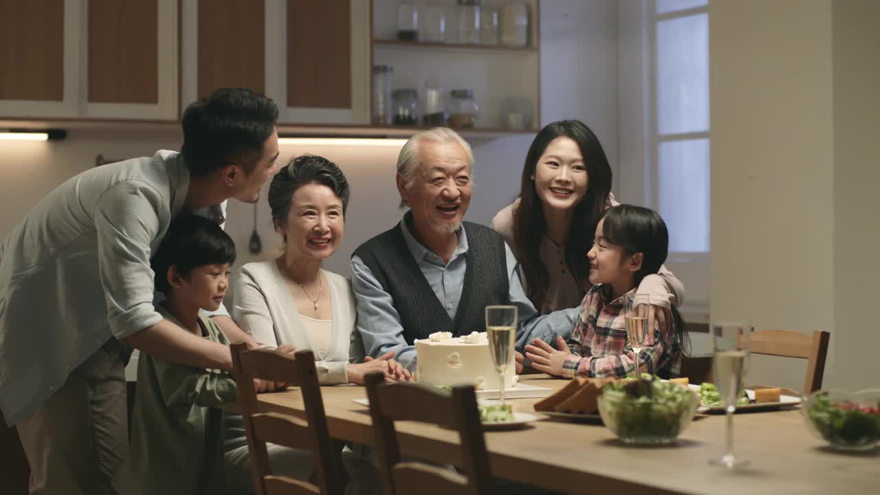 快乐的亚洲家庭坐在餐桌前合影视频下载