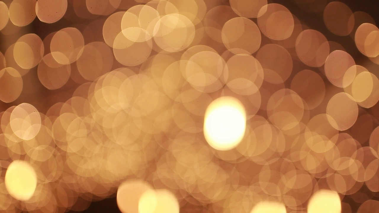 抽象的金色模糊圣诞彩灯散景背景。美丽的夜光闪烁，闪烁的圣诞树灯闪烁。寒假概念。散焦灯与散景火花模式视频素材