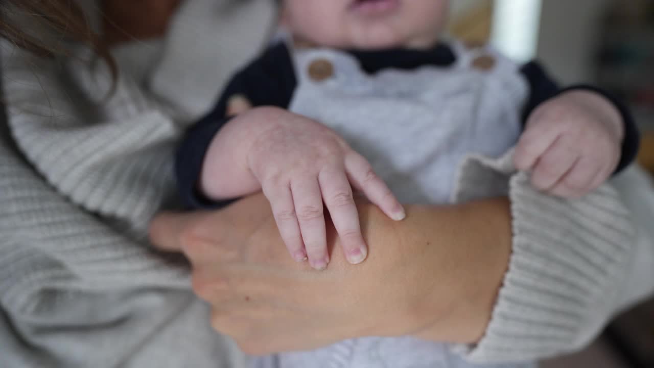 成人手握小婴儿手的细节视频素材