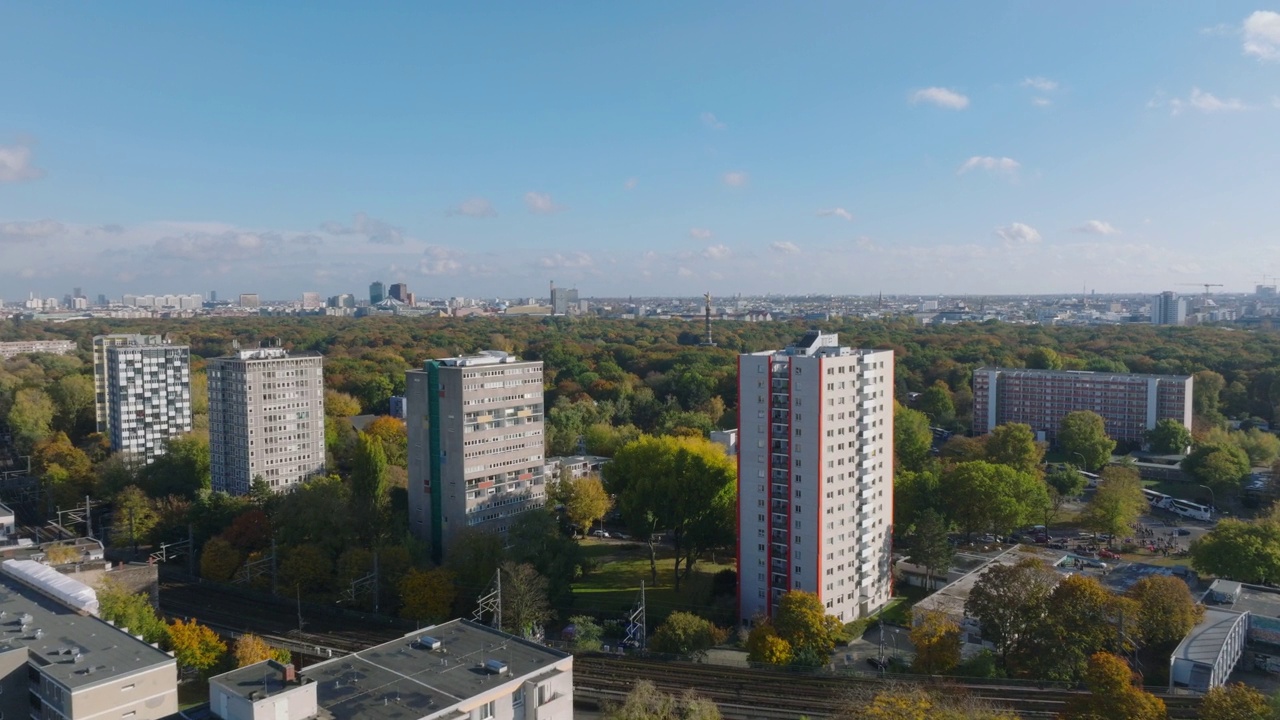 在大型蒂尔加滕公园，前锋飞过高大的住宅楼。城市绿化的鸟瞰图。柏林,德国视频下载
