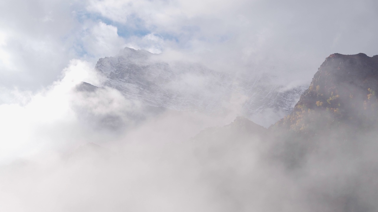 在印度喜马偕尔邦的拉豪尔，冬季风暴期间，4K手持拍摄的云层覆盖着雪山的山峰。冬季，暴风雪的云层覆盖了整个山谷。视频素材
