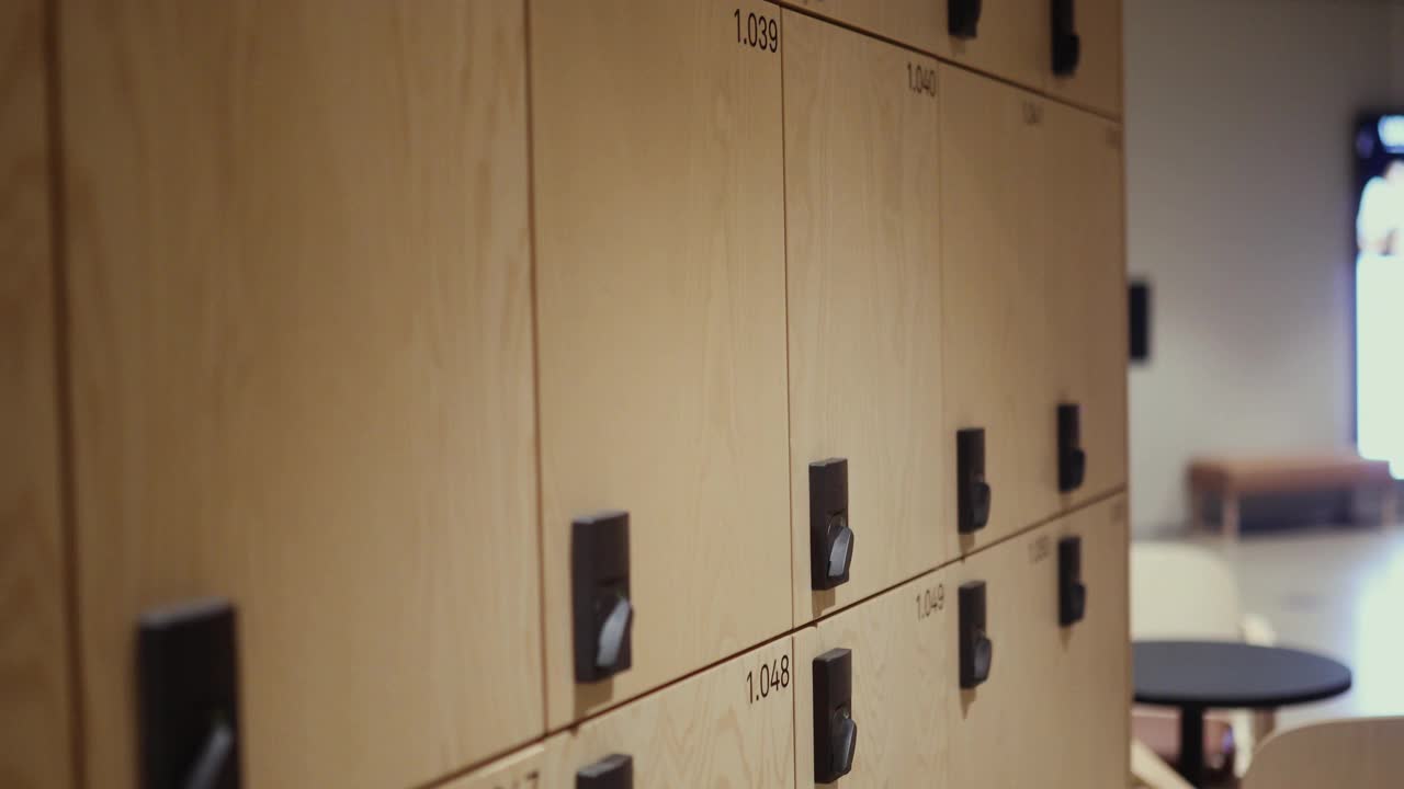 一名女游客用酒店钥匙卡打开酒店大厅的储物柜视频下载