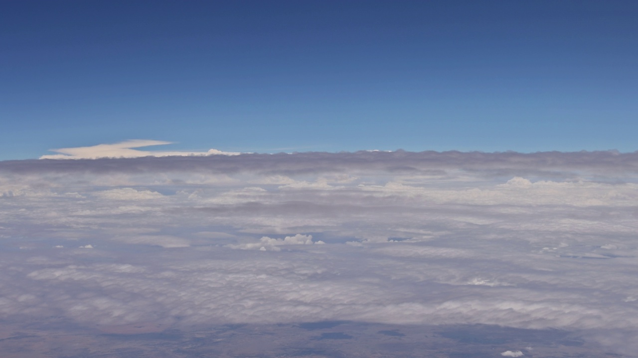 从飞机窗口可以看到美丽的自然景观，蓝天白云。视频下载