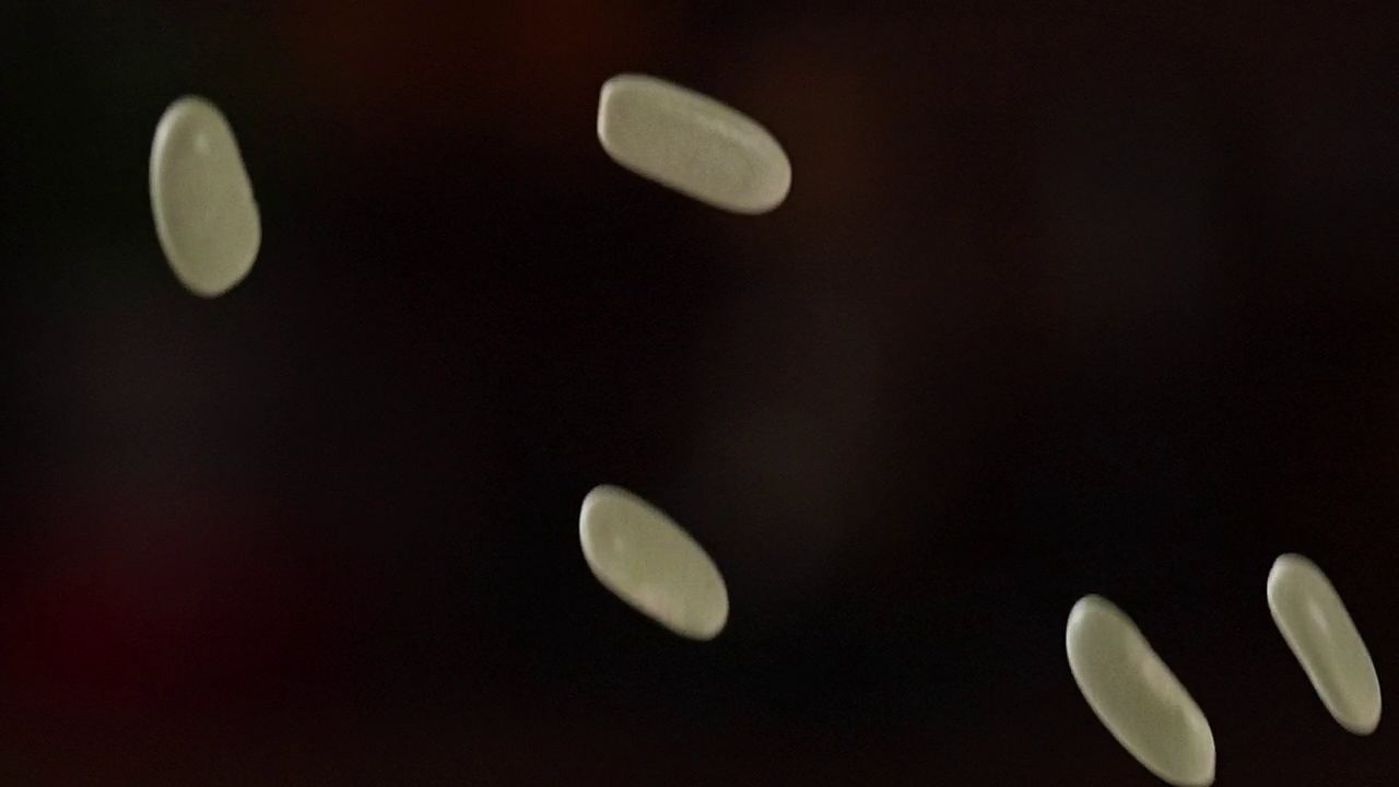 青豆落在黑暗背景上的慢动作视频素材