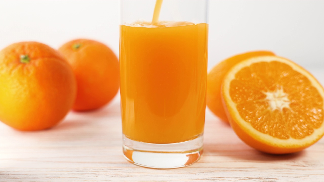 把新鲜的橙汁倒进白色厨房的玻璃杯里。健康营养，有机饮料。维生素c.增强免疫力。增强免疫系统。健康的生活方式理念。橙色水果。视频下载