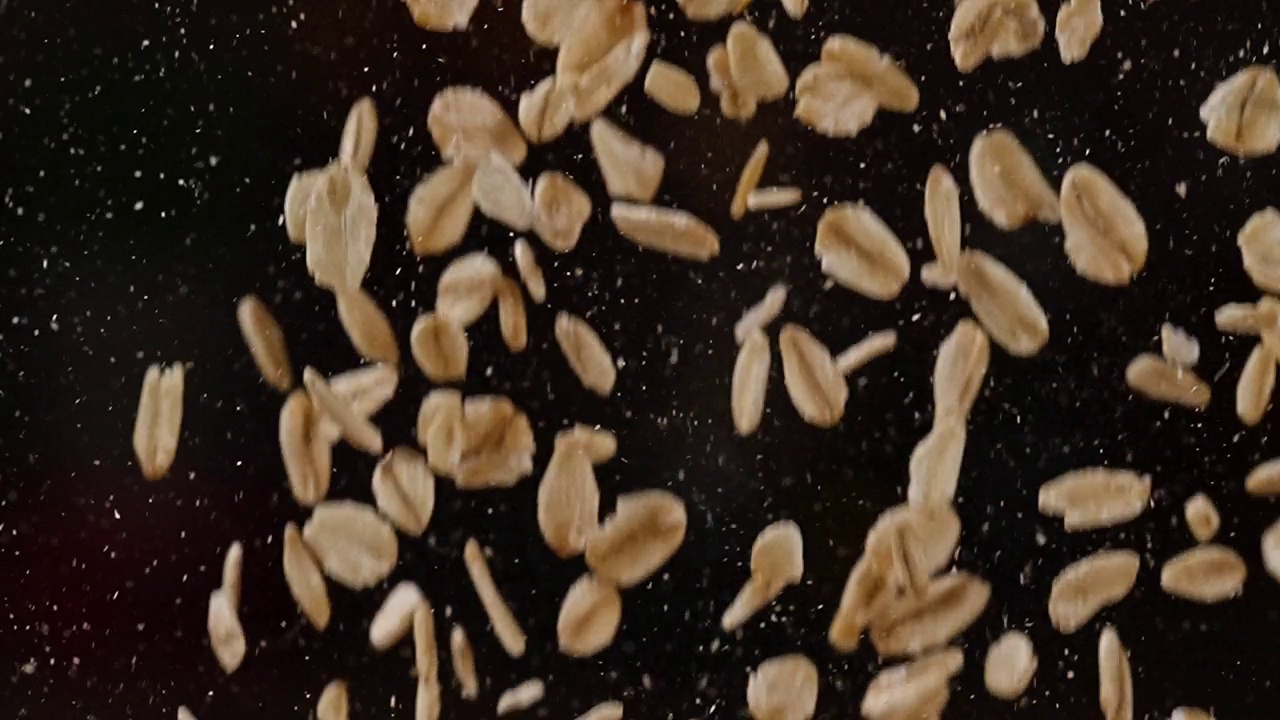 燕麦种子落在黑暗背景上的慢镜头视频素材
