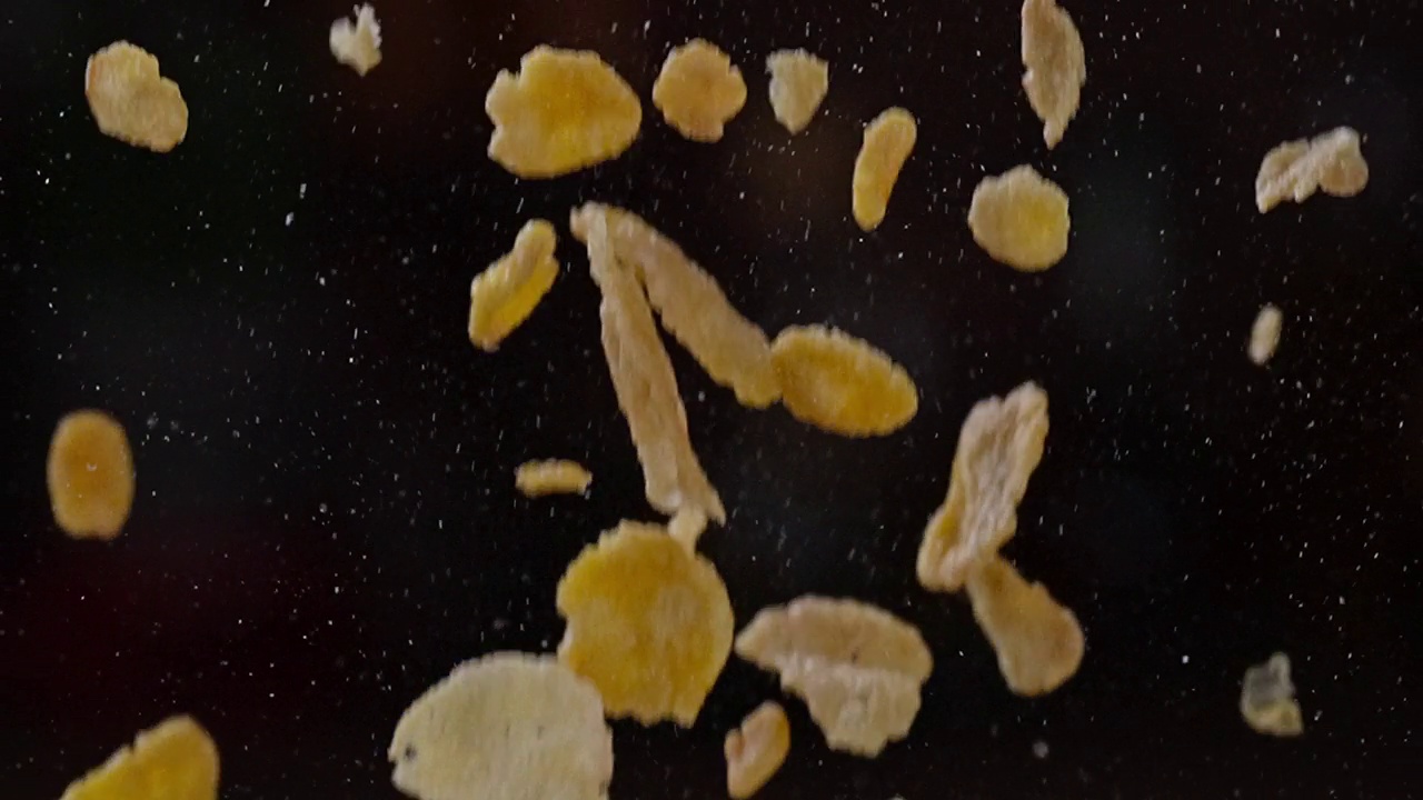 杂粮早餐麦片落在黑暗背景上的慢动作视频素材