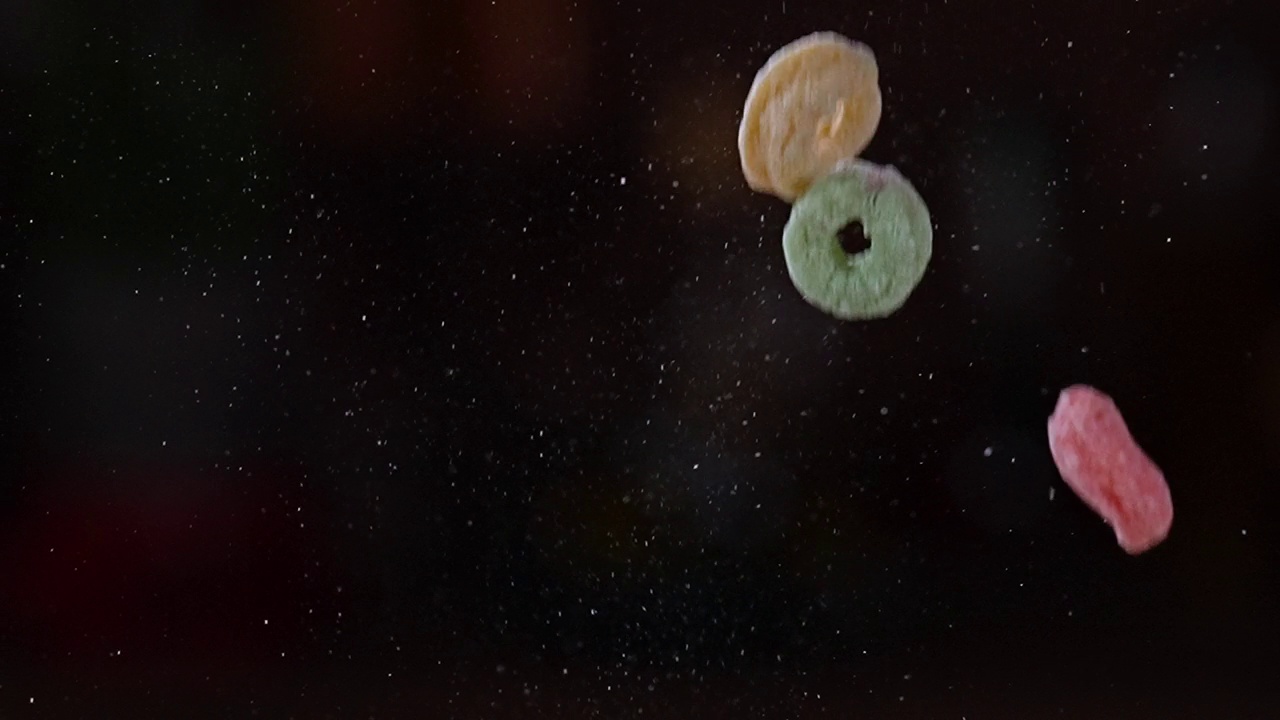 慢动作的杂粮水果环早餐麦片落在黑暗的背景视频素材