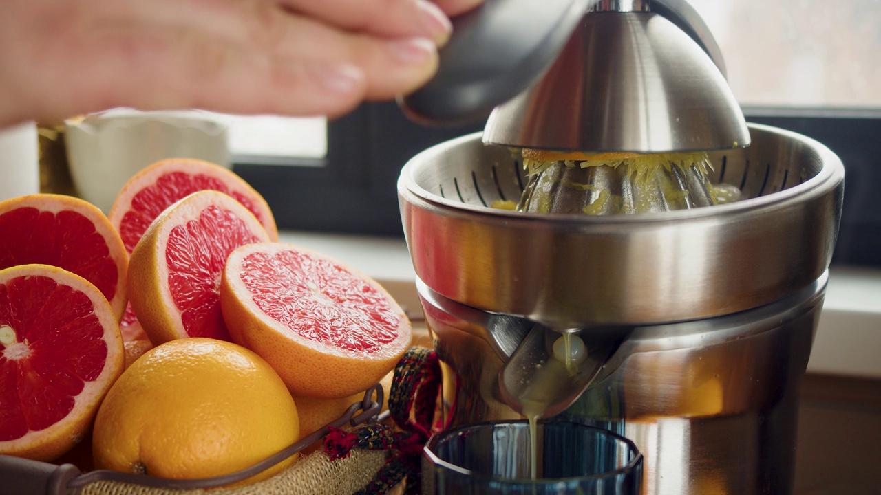 男性用榨汁机榨葡萄柚汁。视频素材
