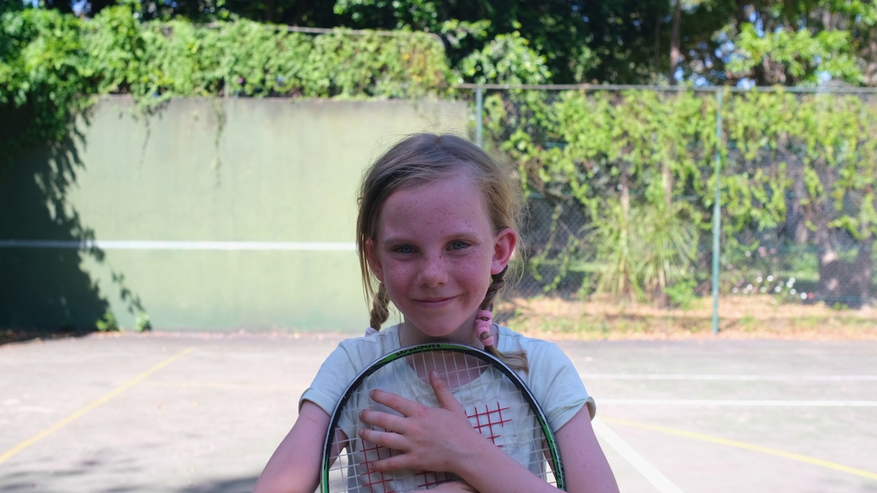 一个年轻女孩在网球场上的肖像视频素材