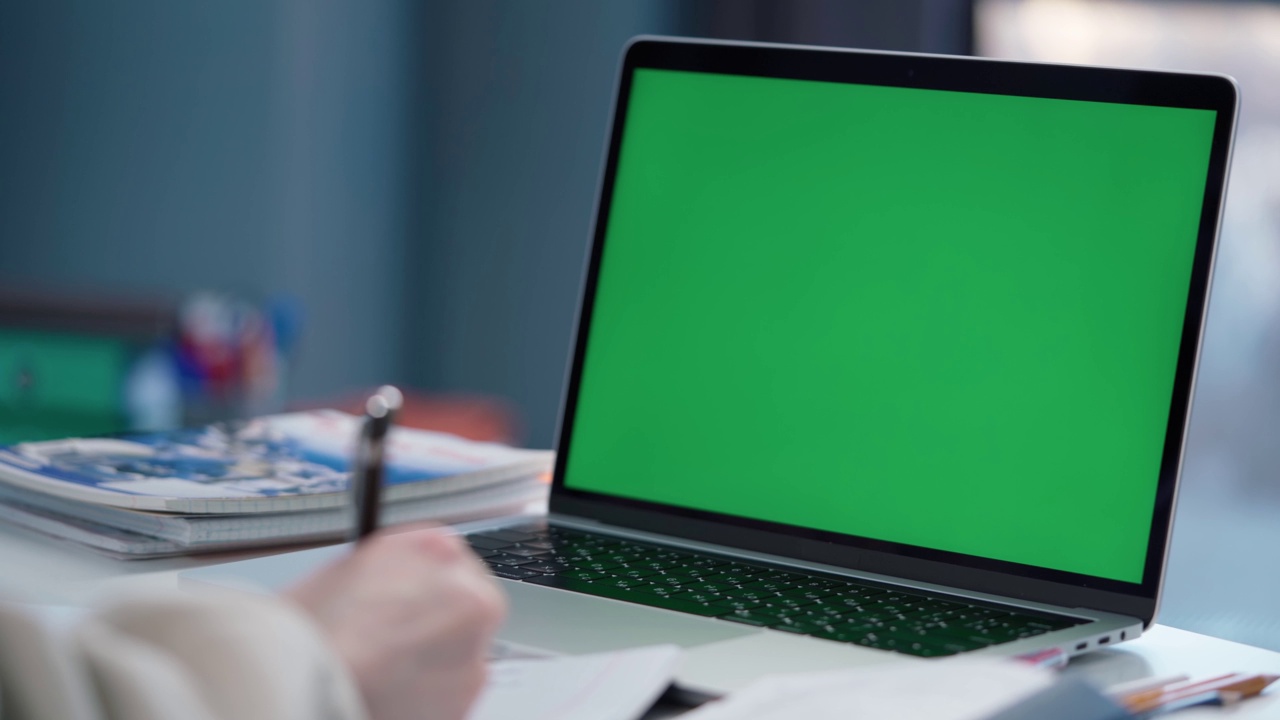 一名女子使用绿色屏幕的笔记本电脑。女学生在网上上课视频素材