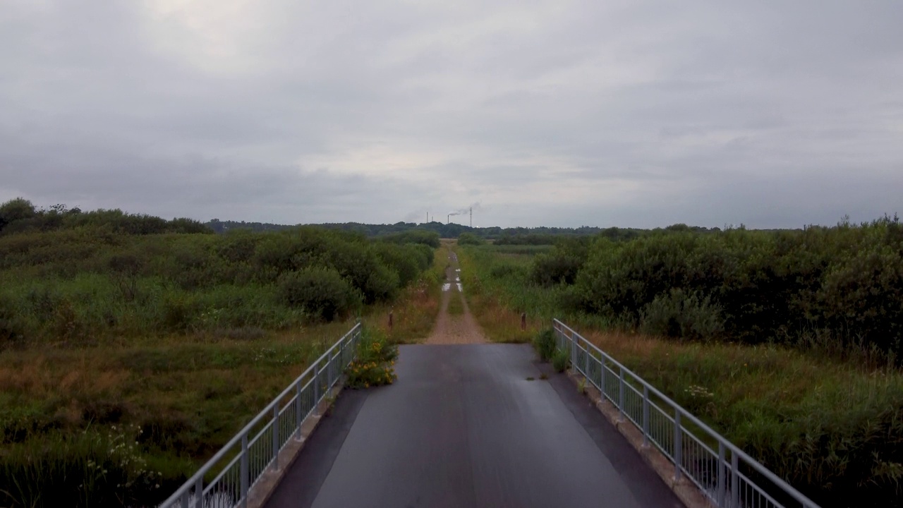 丹麦Romo的一座桥和一条被池塘和沼泽包围的道路视频下载