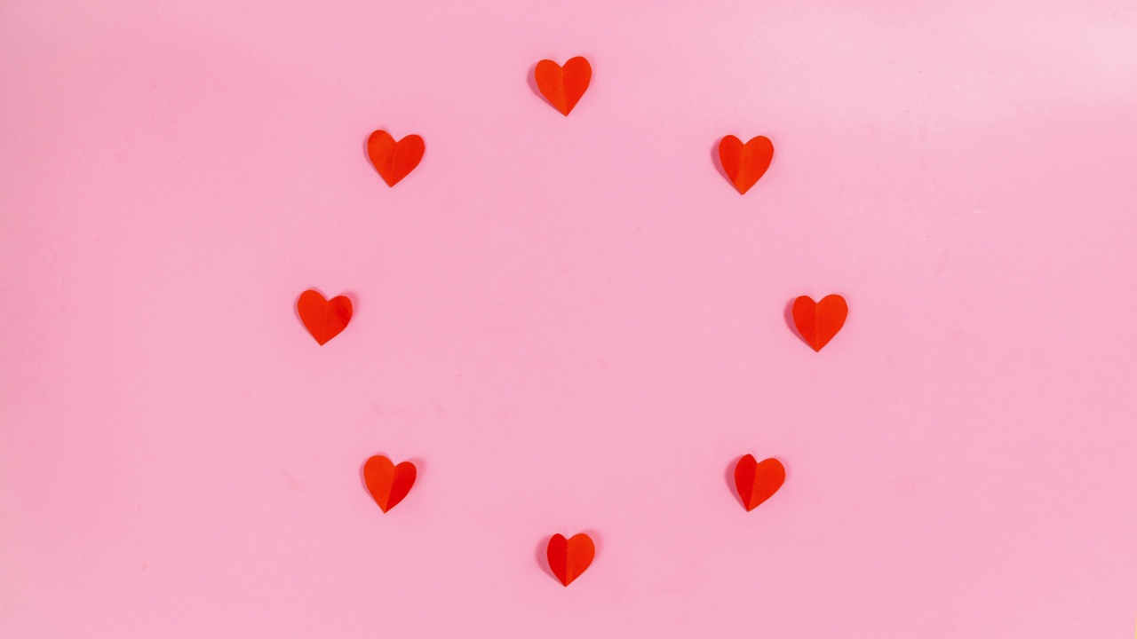 红色的纸心排成一圈，扇动着翅膀。情人节快乐的贺卡。视频下载