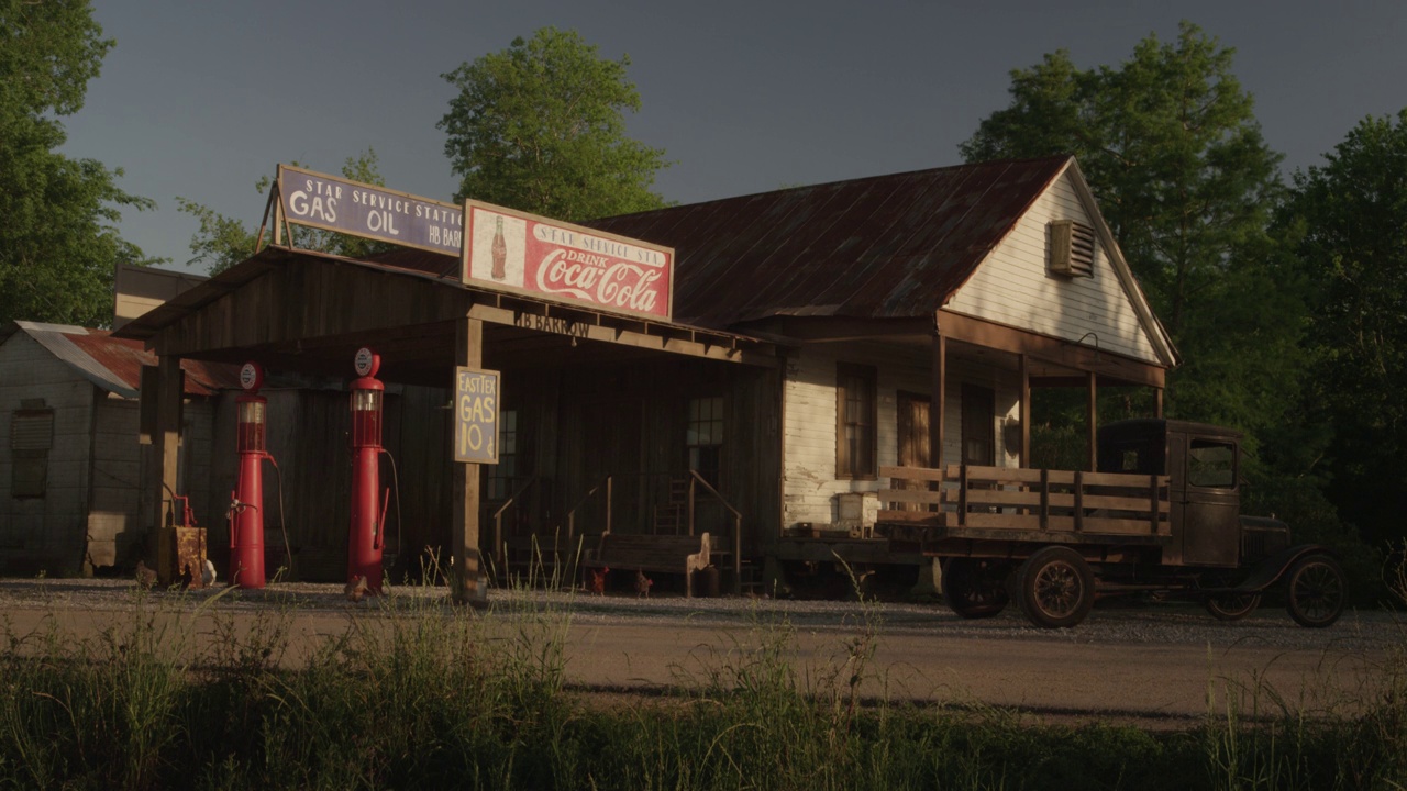 一个老式加油站的广角，有可口可乐的标志，加油站，一辆老式卡车，还有一个写着“星级加油站汽油手推车”的标志。鸡啄地视频下载