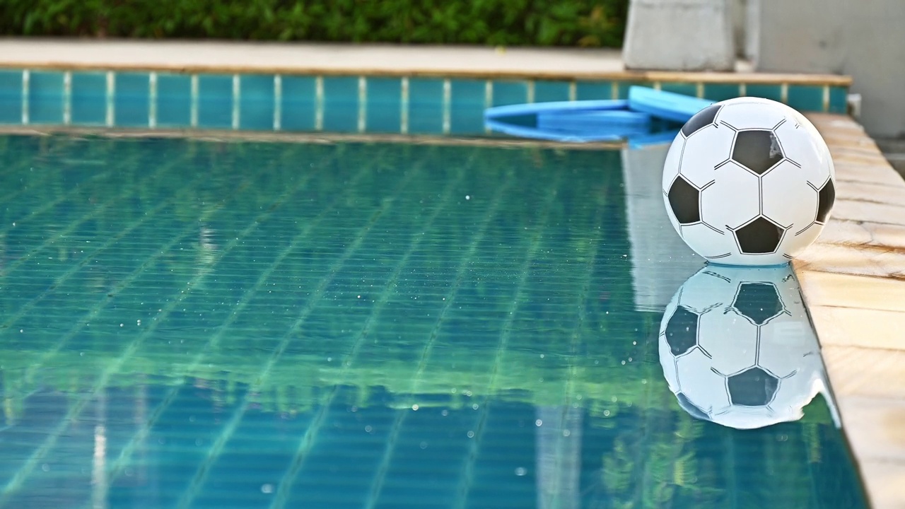 漂浮在游泳池表面的充气足球。视频下载
