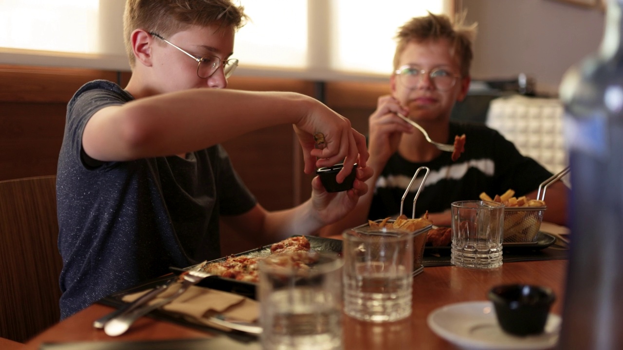 十几岁的男孩在餐厅吃午饭视频素材