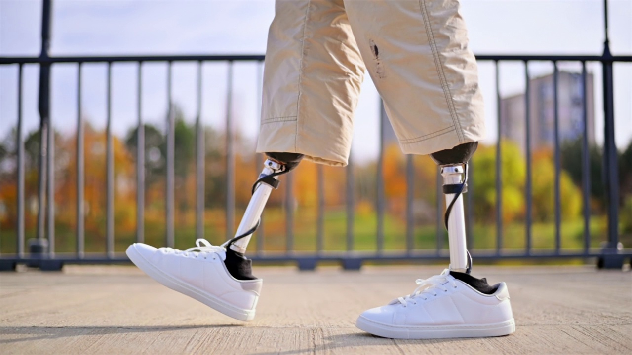 一个穿着假腿和白色运动鞋走路的男人的慢镜头视频下载