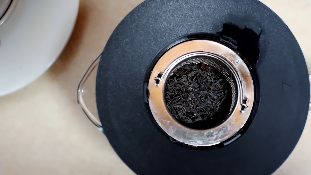 美味的草药茶或红茶是在厨房的玻璃茶壶里冲泡的。视频下载