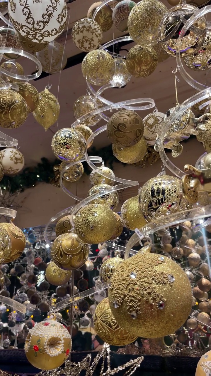 金色的圣诞装饰品悬挂在建筑物的天花板上视频下载