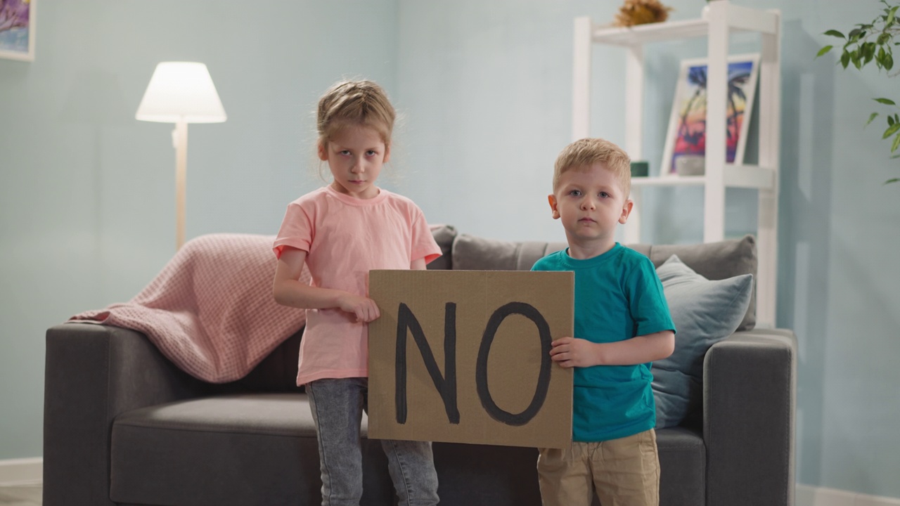 不开心的孩子在客厅展示写着NO的牌子视频下载